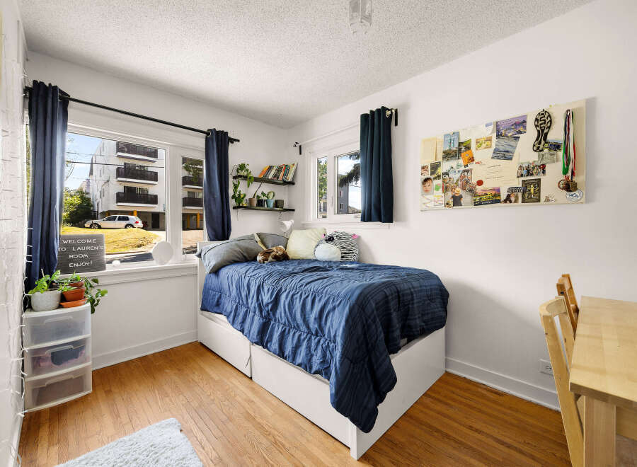 Discover this charming bedroom featuring a comfortable bed with a navy blue comforter, perfect for relaxation.