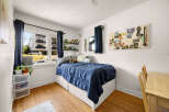Discover this charming bedroom featuring a comfortable bed with a navy blue comforter, perfect for relaxation.