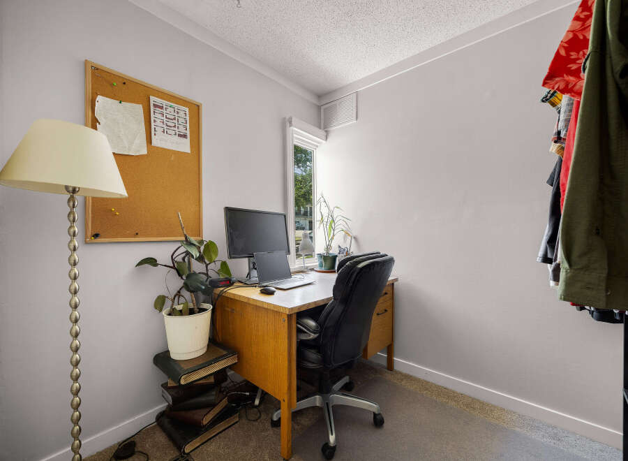 This home office features a functional desk with a computer setup, perfect for remote work or study.
