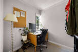 This home office features a functional desk with a computer setup, perfect for remote work or study.