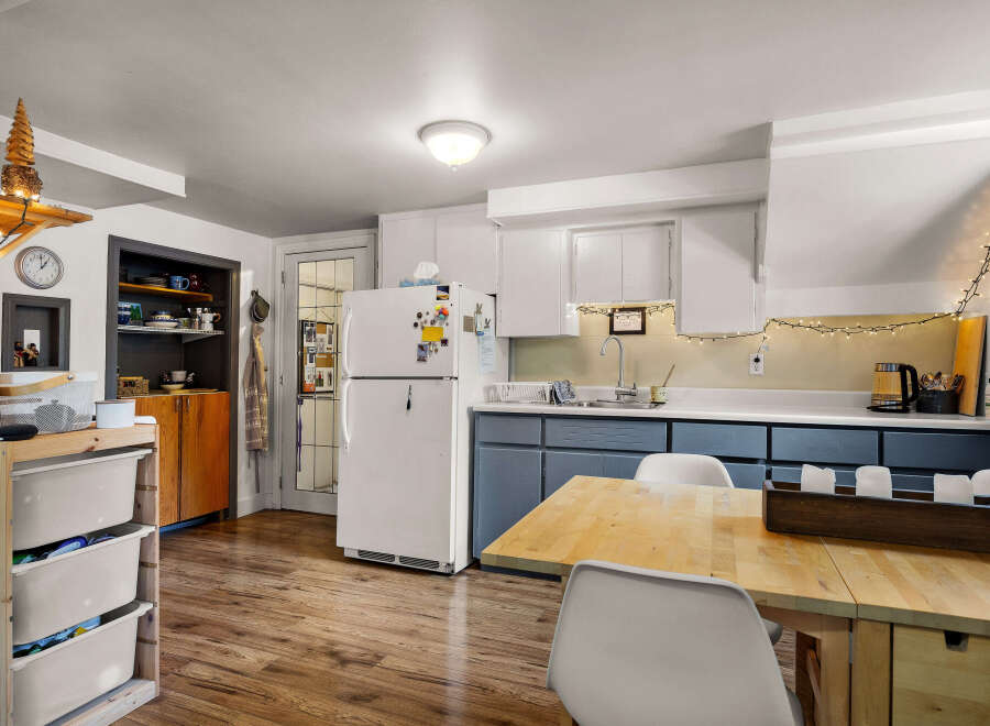 Discover this charming kitchen featuring a spacious refrigerator, ample cabinet storage, and a cozy dining area perfect for meals.