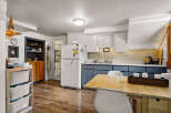 Discover this charming kitchen featuring a spacious refrigerator, ample cabinet storage, and a cozy dining area perfect for meals.