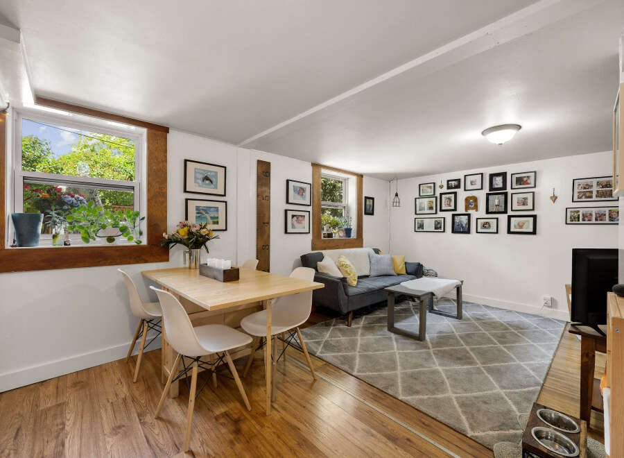 This charming living and dining area features a cozy seating arrangement with a plush sofa and a stylish coffee table, perfect for relaxation.