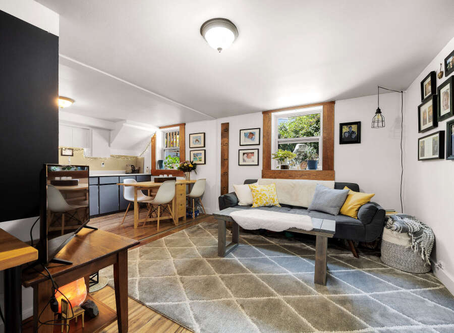 Discover this charming living space featuring a cozy sofa adorned with decorative pillows and a plush throw, perfect for relaxation.