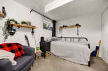 Discover a cozy bedroom featuring a comfortable bed with plush bedding and a stylish black metal frame.