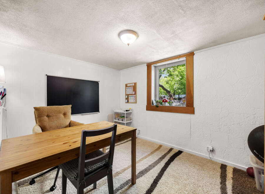 This home office features a large wooden desk and a comfortable accent chair, perfect for productive work sessions.