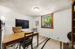 This home office features a large wooden desk and a comfortable accent chair, perfect for productive work sessions.