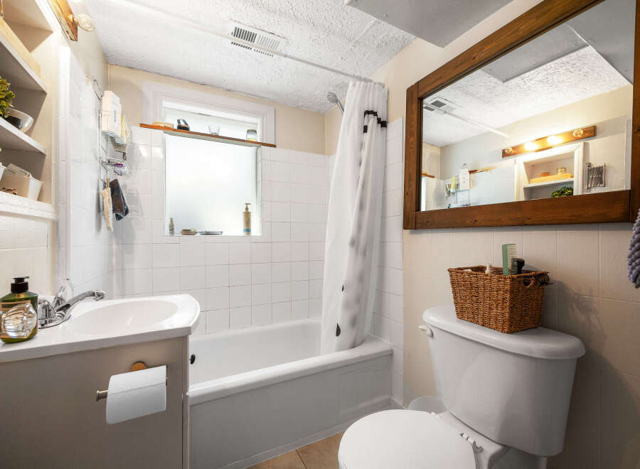 This charming bathroom features a classic white tiled shower and tub combo, perfect for relaxing soaks.