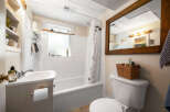 This charming bathroom features a classic white tiled shower and tub combo, perfect for relaxing soaks.