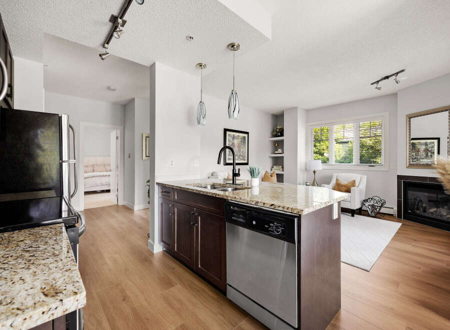 Experience modern living in this stunning condo featuring a sleek kitchen with granite countertops and a spacious island perfect for entertaining.