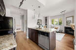 Experience modern living in this stunning condo featuring a sleek kitchen with granite countertops and a spacious island perfect for entertaining.