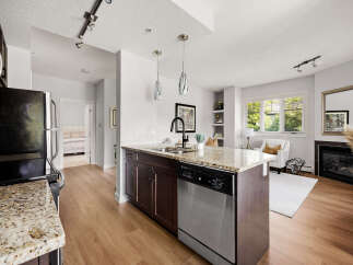 Experience modern living in this stunning condo featuring a sleek kitchen with granite countertops and a spacious island perfect for entertaining.