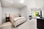 This inviting bedroom features a plush king-sized bed with a textured headboard, complemented by elegant bedside tables and lamps.