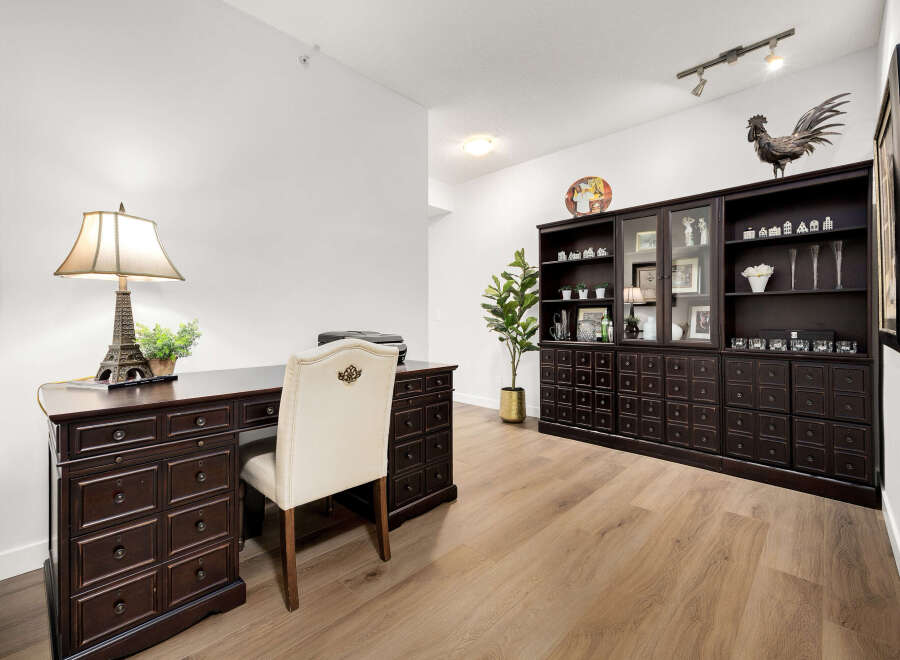 This home office features a classic dark wood desk with an Eiffel Tower lamp and a matching executive chair.