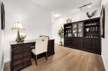 This home office features a classic dark wood desk with an Eiffel Tower lamp and a matching executive chair.