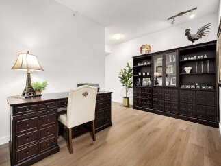 This home office features a classic dark wood desk with an Eiffel Tower lamp and a matching executive chair.