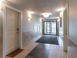 Welcome to this inviting apartment hallway, featuring a well-lit and clean environment.