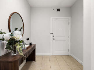 Welcome guests into this inviting entryway featuring a sleek console table adorned with a beautiful floral arrangement and a decorative mirror.