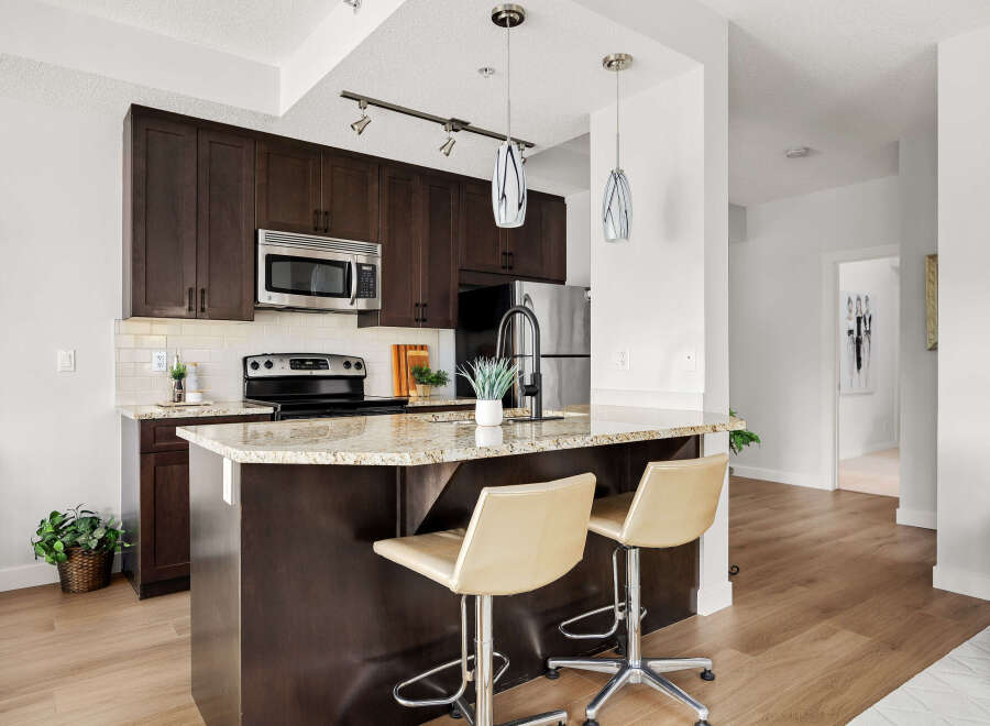 Experience modern living in this stunning kitchen featuring dark wood cabinetry, granite countertops, and a sleek island perfect for casual dining.