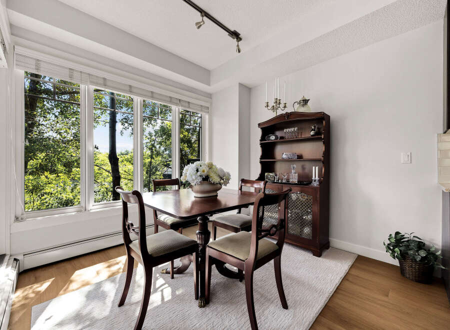 Enjoy bright and airy meals in this charming dining room, bathed in natural light from large windows overlooking lush greenery.