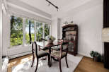 Enjoy bright and airy meals in this charming dining room, bathed in natural light from large windows overlooking lush greenery.