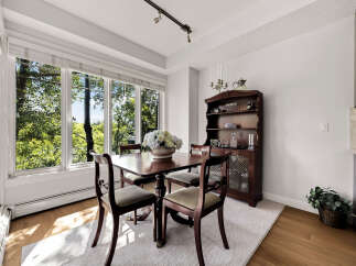 Enjoy bright and airy meals in this charming dining room, bathed in natural light from large windows overlooking lush greenery.