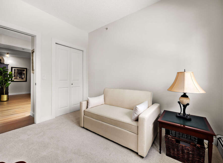This inviting living space features a comfortable sofa bed, perfect for accommodating guests, and a stylish side table with a classic lamp.