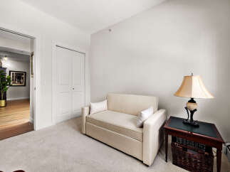 This inviting living space features a comfortable sofa bed, perfect for accommodating guests, and a stylish side table with a classic lamp.