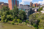 Experience luxury living with this stunning property featuring a modern condo building nestled beside a serene river.