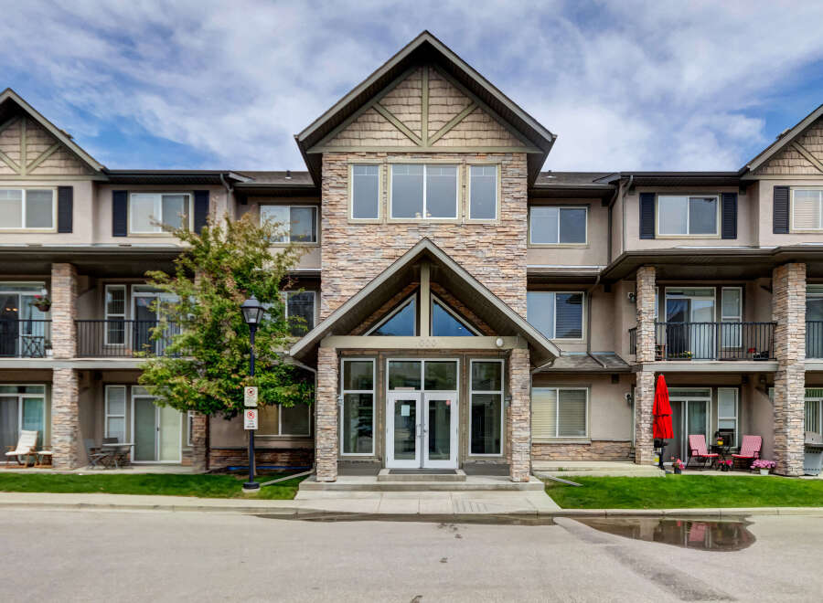 Discover modern living in this stunning multi-story apartment building, featuring a striking stone facade and elegant architectural details.