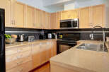 This kitchen boasts modern light wood cabinetry and sleek countertops, offering ample storage and workspace.