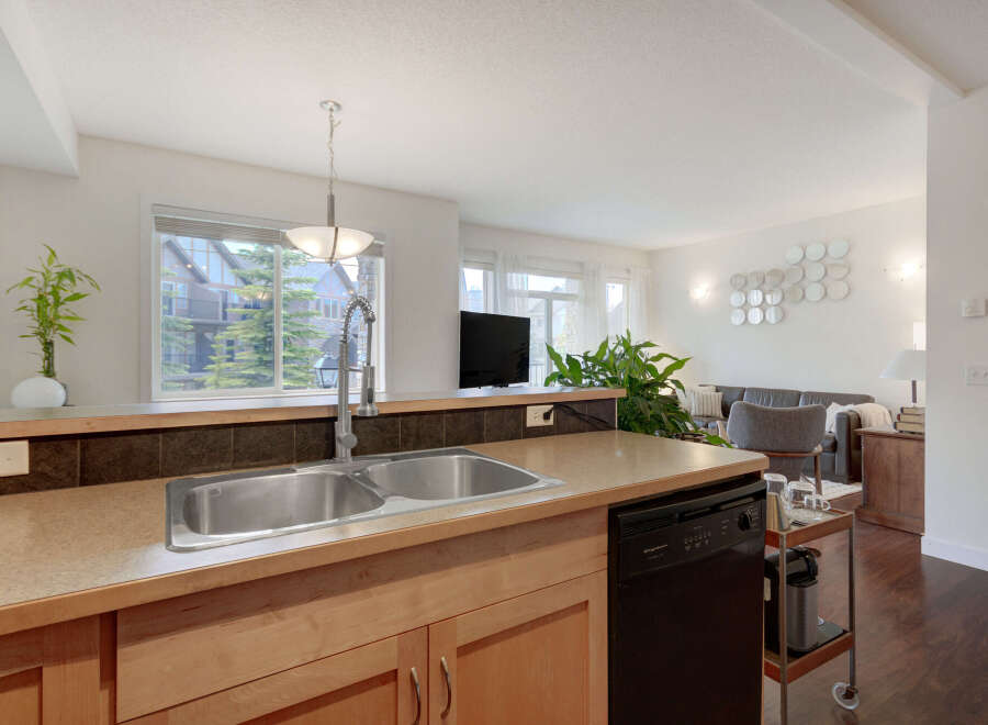 This spacious kitchen features a double stainless steel sink, ample counter space, and a dishwasher, perfect for entertaining.