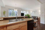 This spacious kitchen features a double stainless steel sink, ample counter space, and a dishwasher, perfect for entertaining.