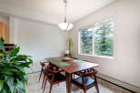 Enjoy meals in this charming dining area, featuring a rich wooden table set with green placemats and elegant chairs.