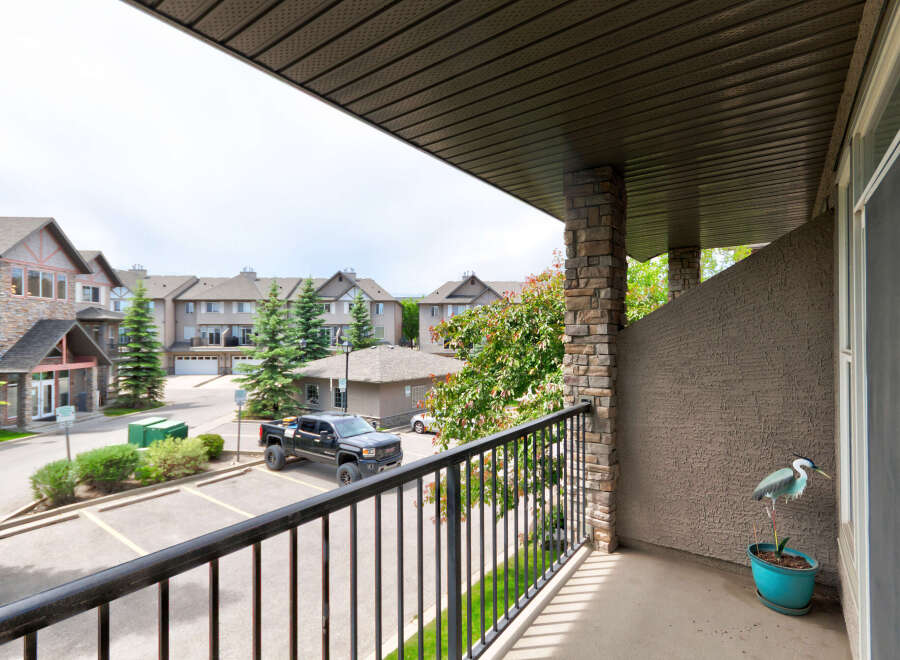 Enjoy your morning coffee on this private balcony overlooking a well-maintained complex with ample parking and green spaces.