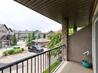 Enjoy your morning coffee on this private balcony overlooking a well-maintained complex with ample parking and green spaces.
