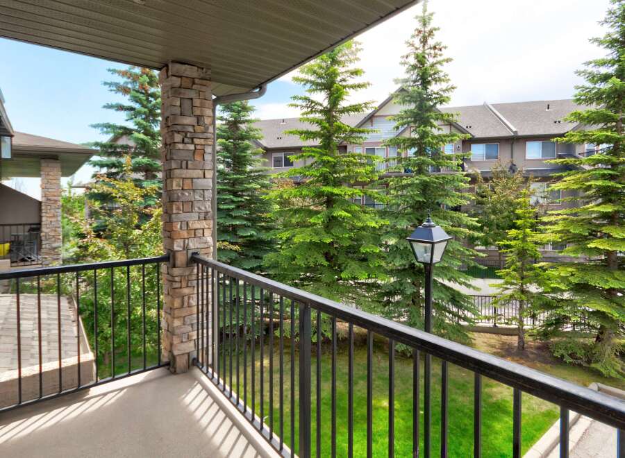 Enjoy your morning coffee on this private balcony overlooking lush greenery and mature trees.