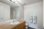 This bright and clean bathroom features a spacious vanity with a large mirror, perfect for your morning routine.