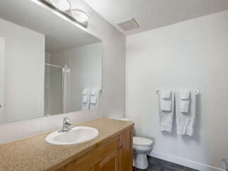 This bright and clean bathroom features a spacious vanity with a large mirror, perfect for your morning routine.