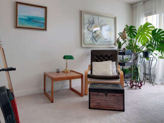 This living room features a comfortable armchair with a plush cushion, perfect for relaxing.