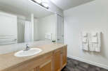 This bright and airy bathroom features a spacious vanity with ample counter space and a clean white sink.