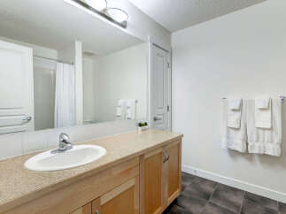 This bright and airy bathroom features a spacious vanity with ample counter space and a clean white sink.