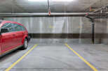 Discover convenient and secure parking at this property, featuring a spacious red SUV parked in a designated spot.