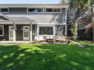 Charming townhome living awaits with a welcoming front porch and a private patio perfect for outdoor relaxation.