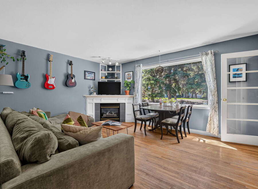 This inviting living and dining area features a comfortable sectional sofa, a cozy fireplace, and a stylish dining set perfect for family meals.