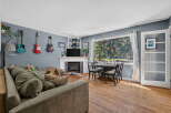 This inviting living and dining area features a comfortable sectional sofa, a cozy fireplace, and a stylish dining set perfect for family meals.