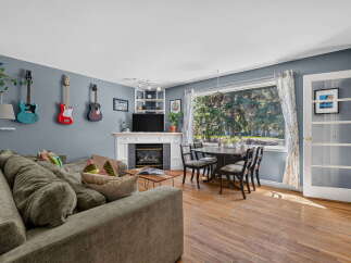 This inviting living and dining area features a comfortable sectional sofa, a cozy fireplace, and a stylish dining set perfect for family meals.