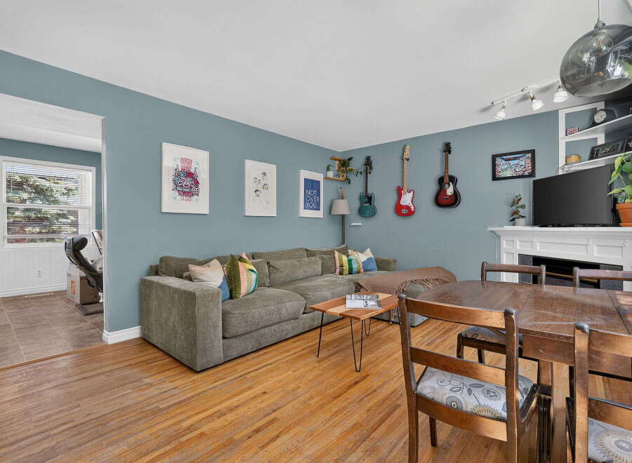 This inviting living room features a spacious sectional sofa perfect for relaxation, complemented by decorative guitars mounted on the wall for a unique artistic touch.
