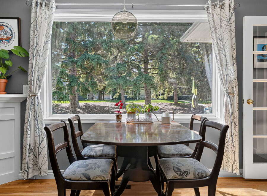 Enjoy bright and airy meals in this charming dining area, featuring a classic wooden table surrounded by four upholstered chairs.