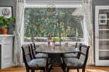 Enjoy bright and airy meals in this charming dining area, featuring a classic wooden table surrounded by four upholstered chairs.